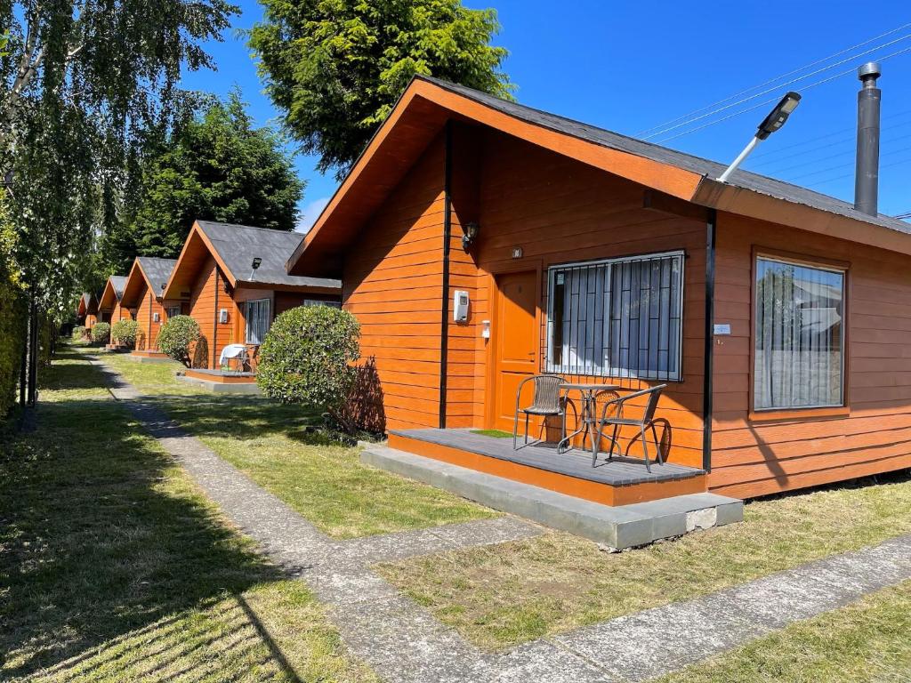 a small cabin with a porch and a table in front of it at Cabañas Kernayel in Pucón