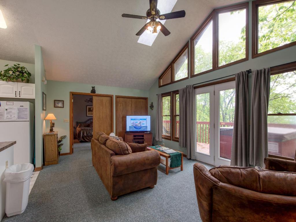 a living room with couches and a tv and windows at Above and Beyond, 2 Bedrooms, Sleeps 6, Private, Amazing View, Hot Tub in Gatlinburg
