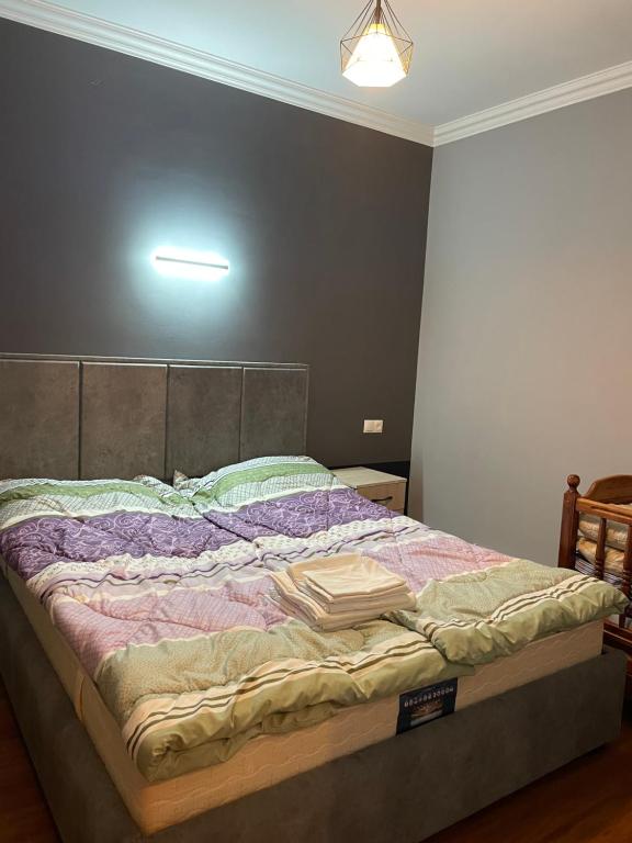 a bedroom with a large bed with a light on it at The Nest JERMUK in Jermuk