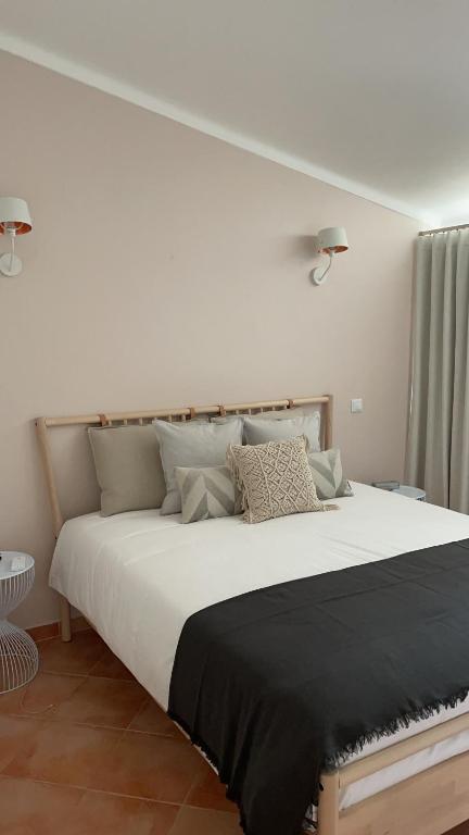 - une chambre avec un grand lit blanc et des oreillers dans l'établissement Ponta Grande Villa 29, à Albufeira