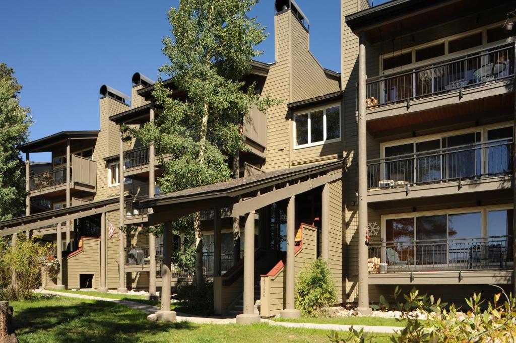 un edificio de apartamentos con balcones y un árbol en The Forest Neighborhood by Keystone Resort, en Keystone