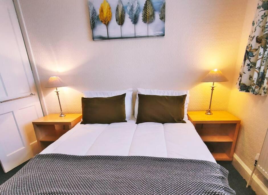 een slaapkamer met een groot bed met twee lampen aan beide zijden bij Wolsey Road, North Oxford in Oxford