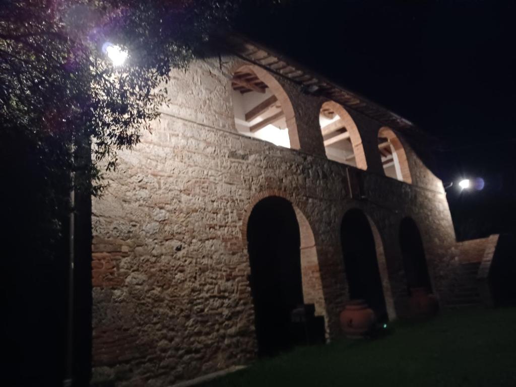 un antiguo edificio de piedra con ventanas por la noche en Agriturismo Caio Alto, en Cetona