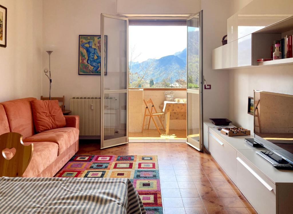 a living room with a couch and a sliding glass door at Mountain view charming apartment in Moggio