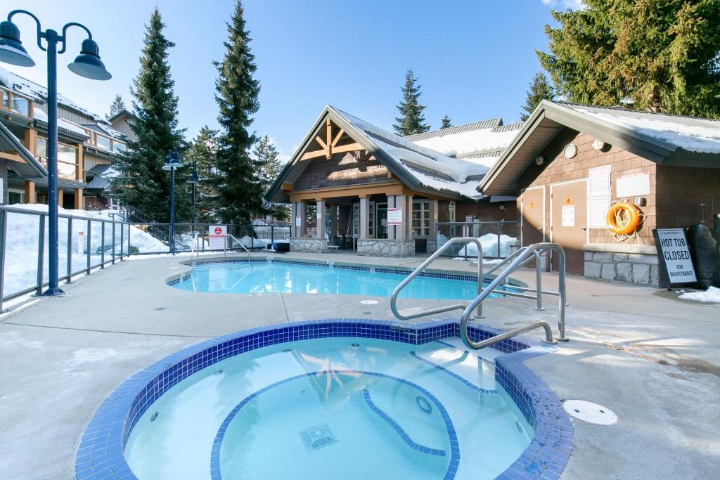 a swimming pool in the snow in front of a house at Glaciers Reach by Allseason Vacation Rentals in Whistler
