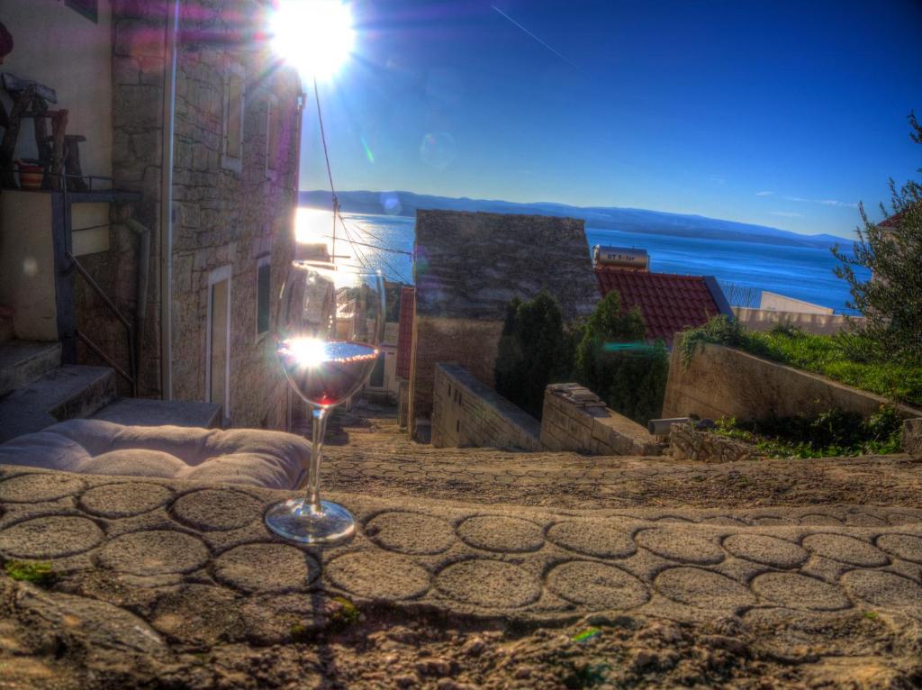 una copa de vino en el suelo frente a un edificio en Bikini Vintage House en Brela