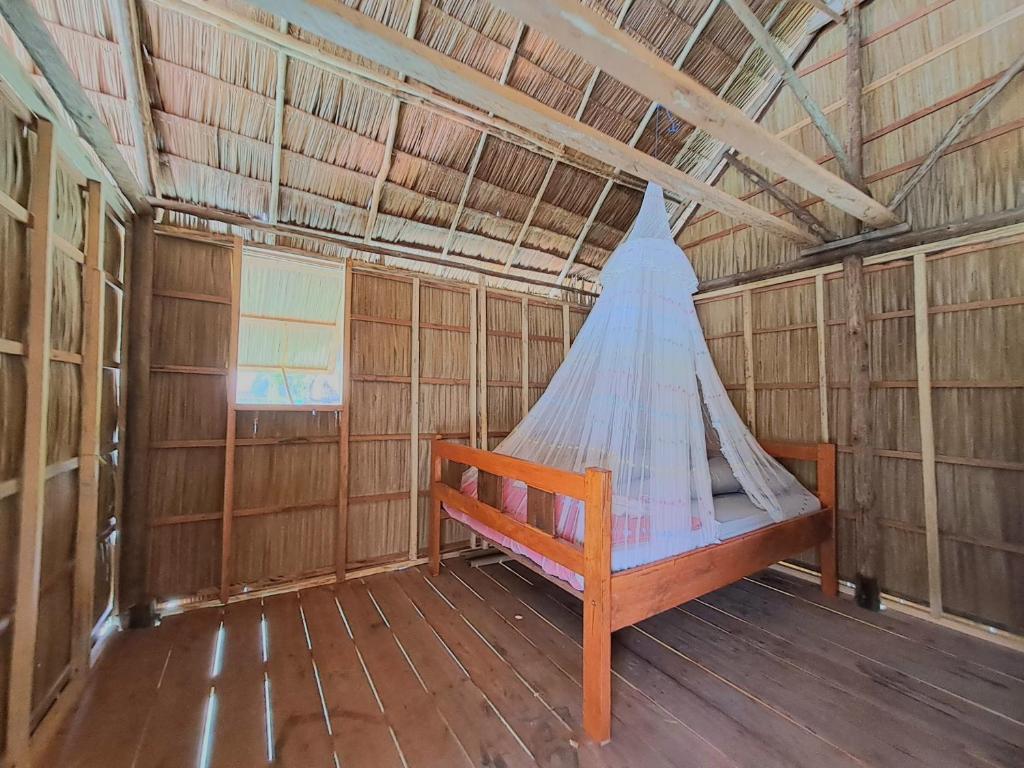 um quarto com uma rede de descanso numa casa de madeira em GAM BAY bungalow's em Besir