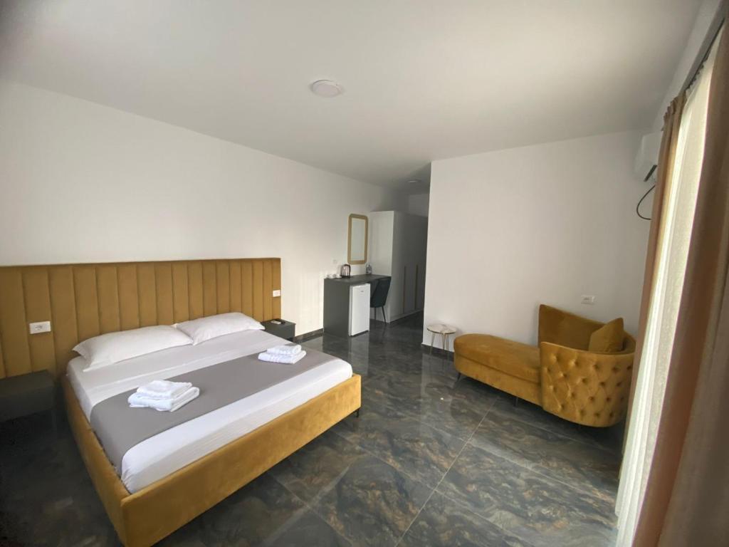 um quarto com uma cama grande e uma cadeira em LEODORI 3 suites em Shëngjin