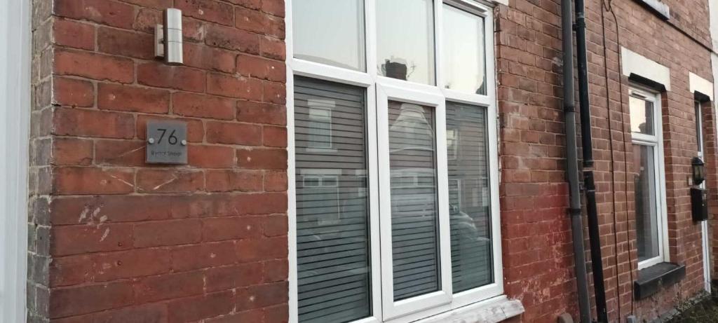 a window with blinds on a brick building at Rydal house with office space newly refurbished in Newton-le-Willows