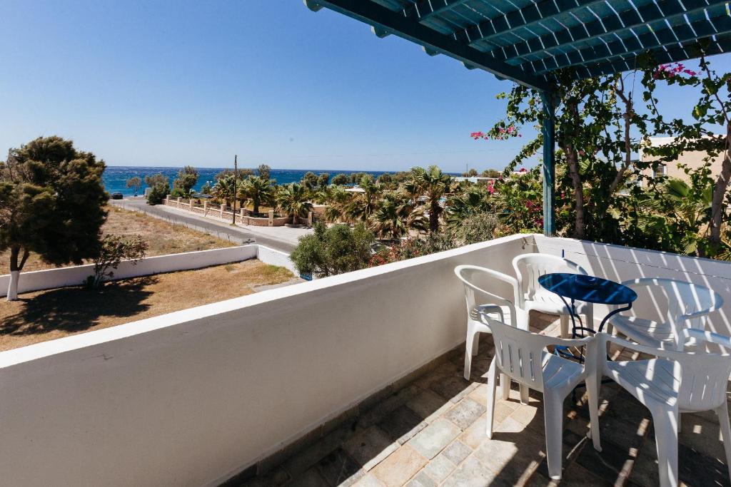 a balcony with a table and chairs and a view of the ocean at Thalassitis Coastal Apartments in Perivolos