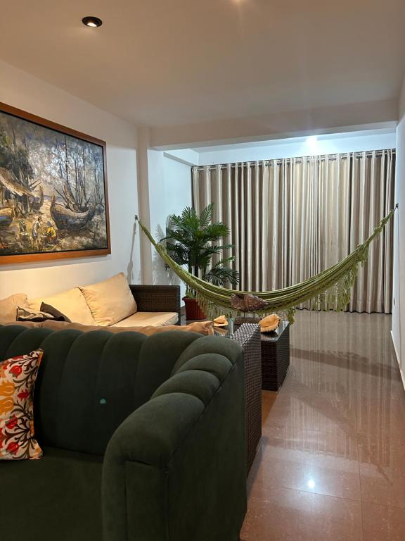 a living room with a couch and a hammock at Apartamento Huanchaco Yuri in Huanchaco