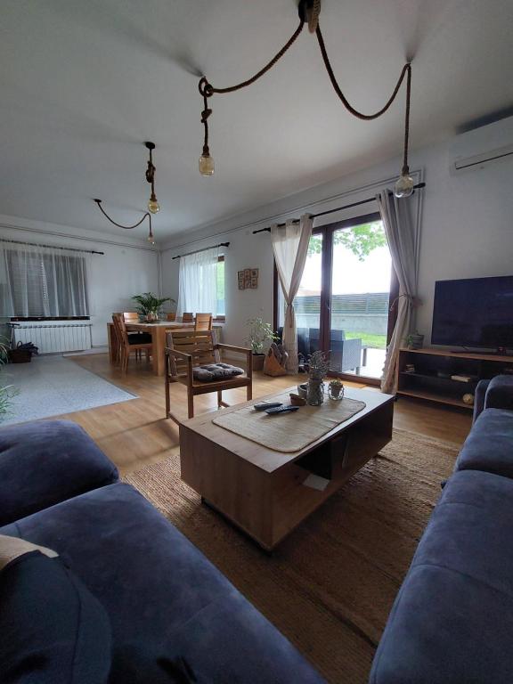 uma sala de estar com um sofá e uma mesa de centro em Che Private Rooms Banovci em Novi Banovci