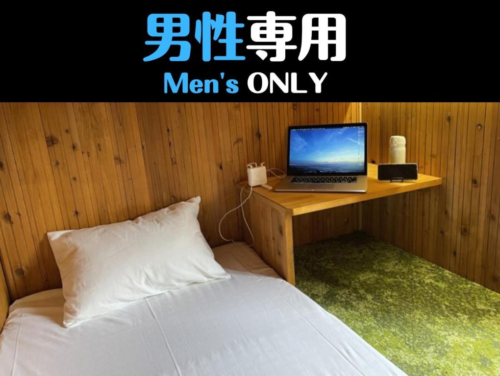 1 dormitorio con cama y escritorio con ordenador portátil en HataraColiving - Vacation STAY 22651v, en Chichibu