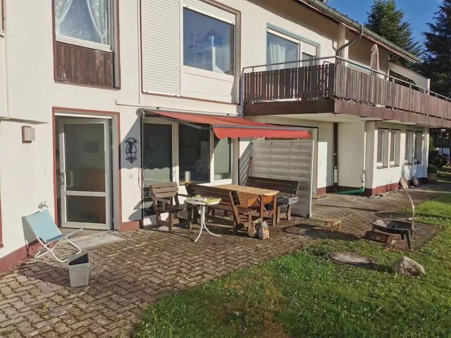 een huis met een patio met een tafel en een terras bij FeWo-Mitten In Schwarzwald in Titisee-Neustadt