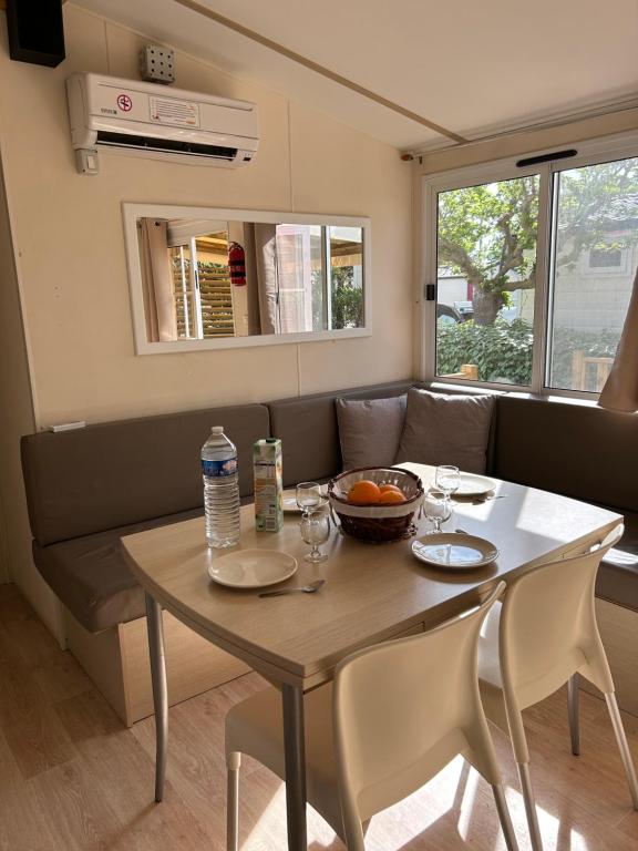 a table with two chairs and a table with food on it at Les mobil homes de Naka , camping le NOVELA in Port-la-Nouvelle