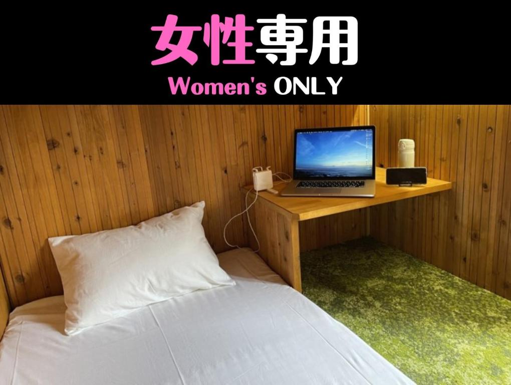 een slaapkamer met een bed en een laptop op een bureau bij HataraColiving - Vacation STAY 24092v in Chichibu