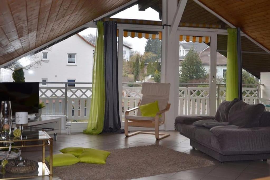 un soggiorno con divano e TV su un portico di Ferienwohnung Kirschenlohr a Ober-Abtsteinach