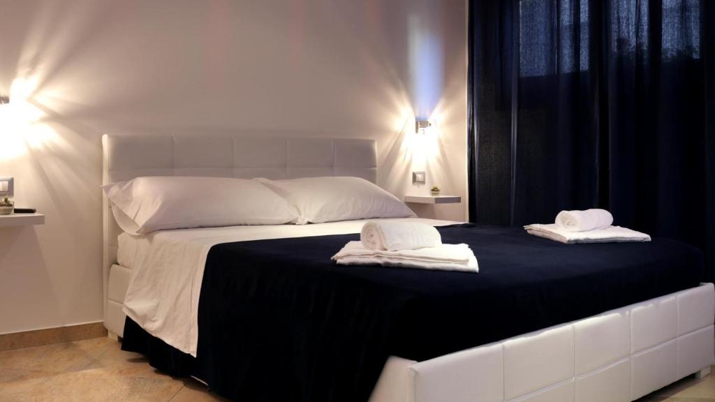 un letto bianco con due asciugamani sopra di Terre Bianche ad Alghero