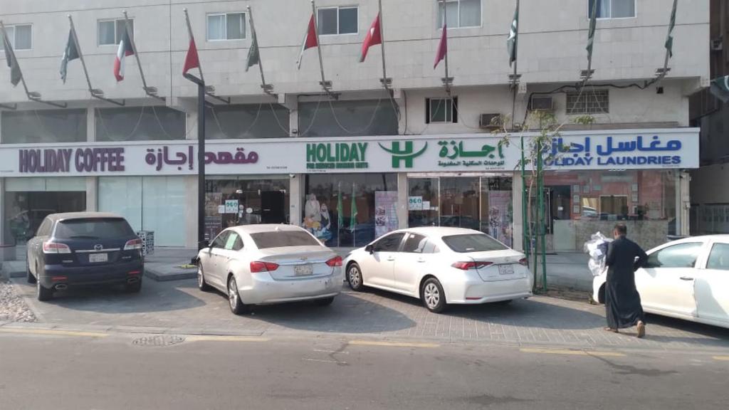 a group of cars parked in front of a store at Holiday Furnished Units in Dammam
