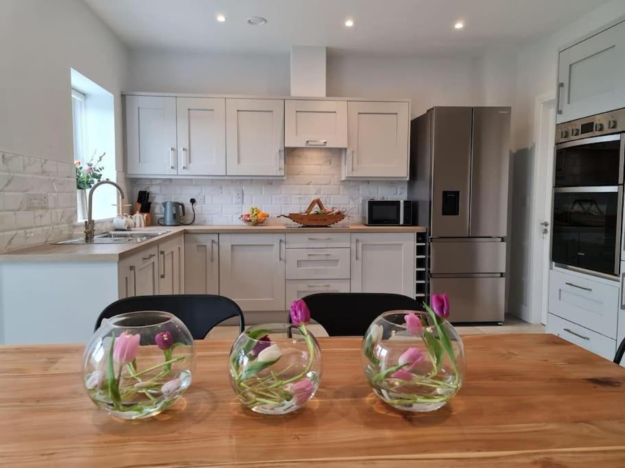 a kitchen with a wooden table with three wine glasses on it at Abbeyfort Kinsale in Kinsale