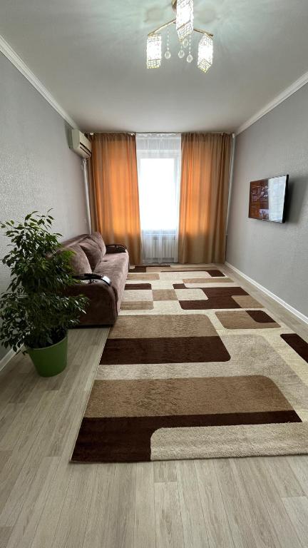 un soggiorno con divano e tappeto di Квартира 6-35 ad Aqtau