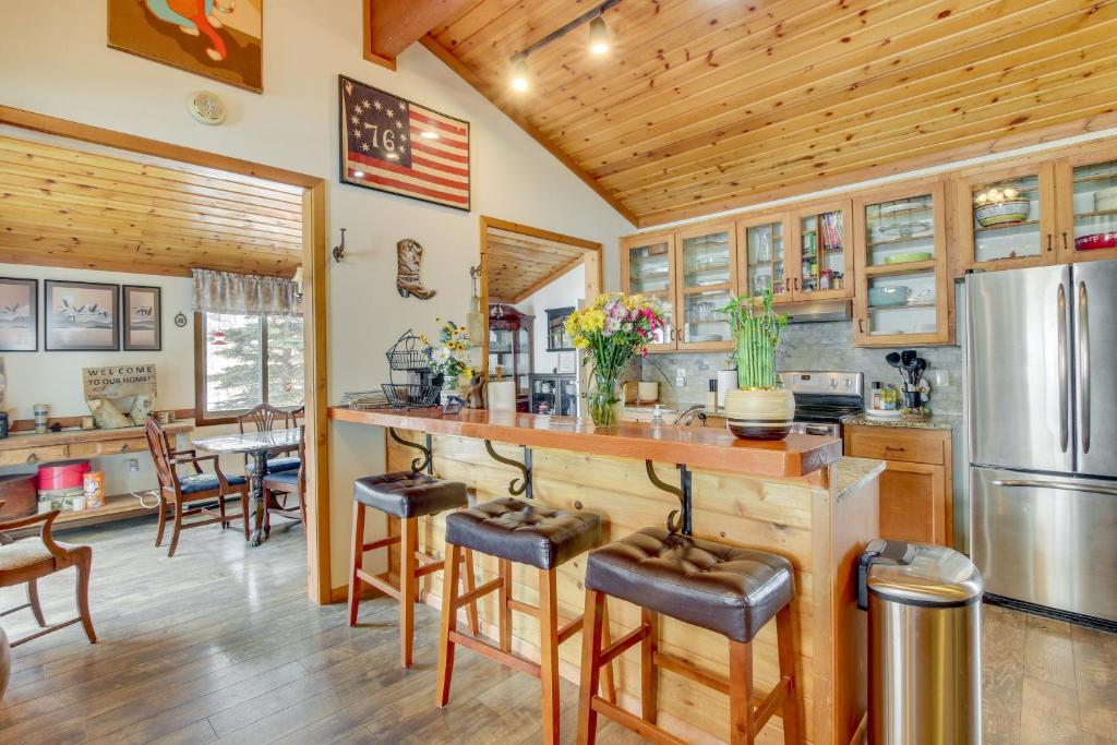 a kitchen with a bar and a dining room at Cozy Mountain Home on 10 Acres with Fire Pit and Games in Thayne