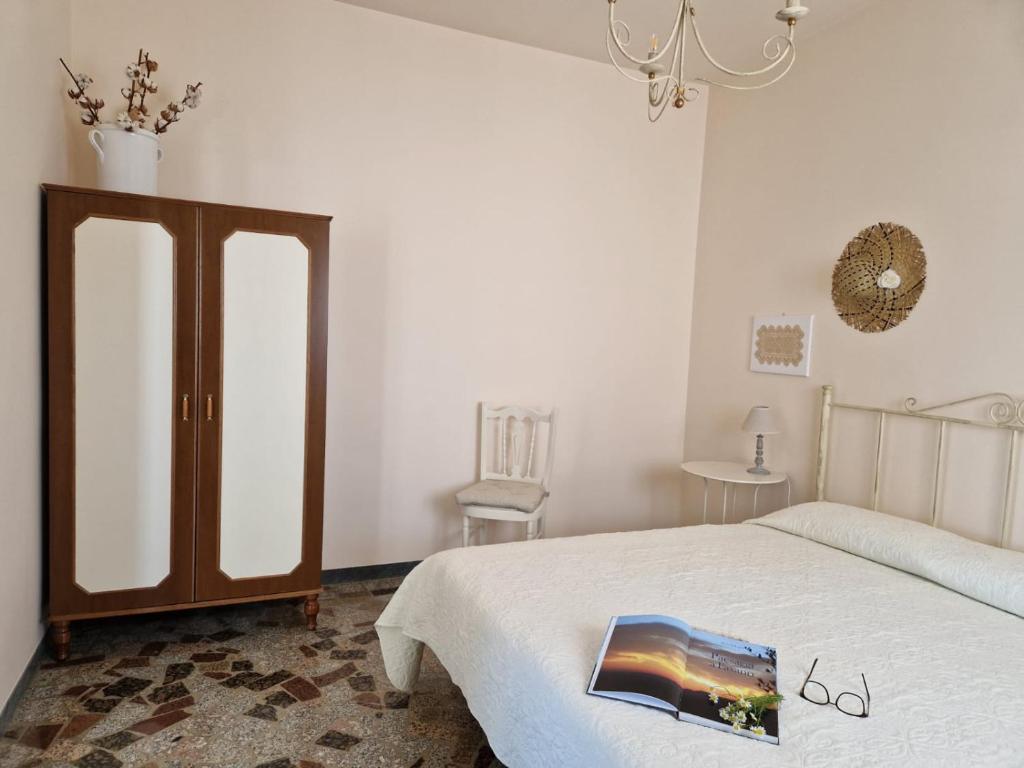 een slaapkamer met een bed en een kroonluchter bij Residenza "I Tre Carrubi " in Fasano