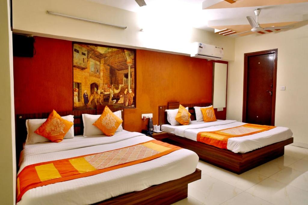 1 dormitorio con 2 camas y un cuadro en la pared en Hotel Royal Stay, Pakwan Sg Highway en Ahmedabad
