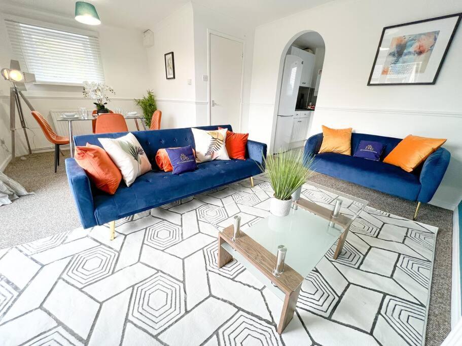 a living room with a blue couch and a table at 2 Bedroom Flat - Free Parking in Shenley Church End