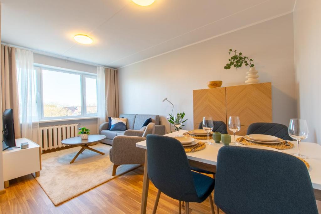 a dining room and living room with a table and chairs at Stylish Central Apartment by Kuus Sõlme in Kuressaare