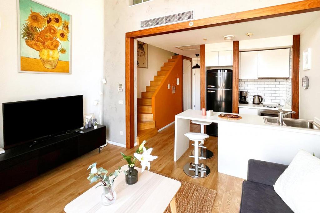 TV a/nebo společenská místnost v ubytování Cozy Loft with Skyline View in Modern Residence