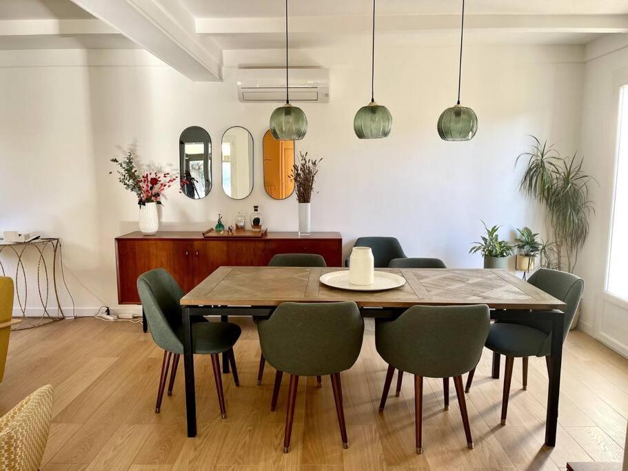 una sala da pranzo con tavolo e sedie in legno di Maison et Piscine à 10min d’Aix/20min de Marseille a Bouc-Bel-Air