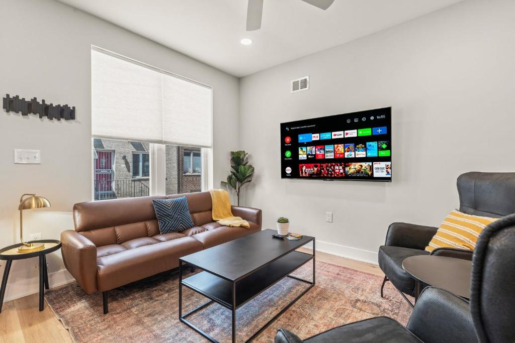 uma sala de estar com um sofá e uma televisão na parede em Family Fun South Philly Game House Near Sports Stadiums and Concerts em Filadélfia