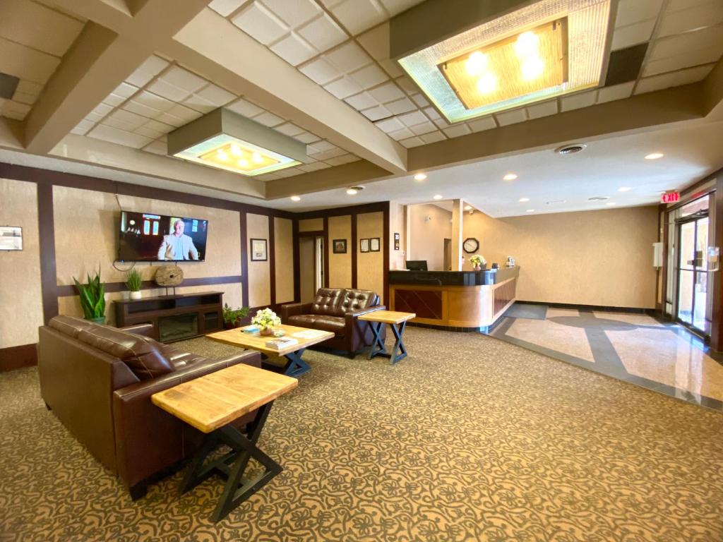 vestíbulo de un hospital con sofá y mesa en The George Dawson Inn & Conference Centre, en Dawson Creek