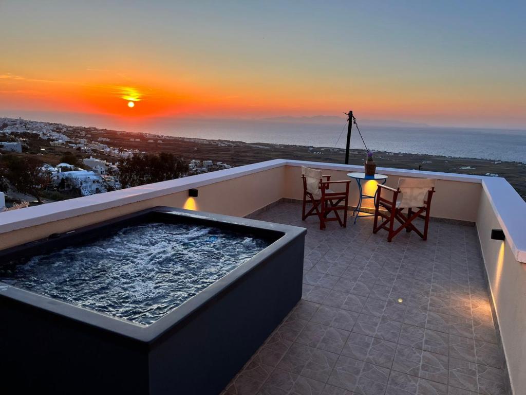 una vasca idromassaggio su un balcone con vista sul tramonto di Sunset Paradise Oia a Oia