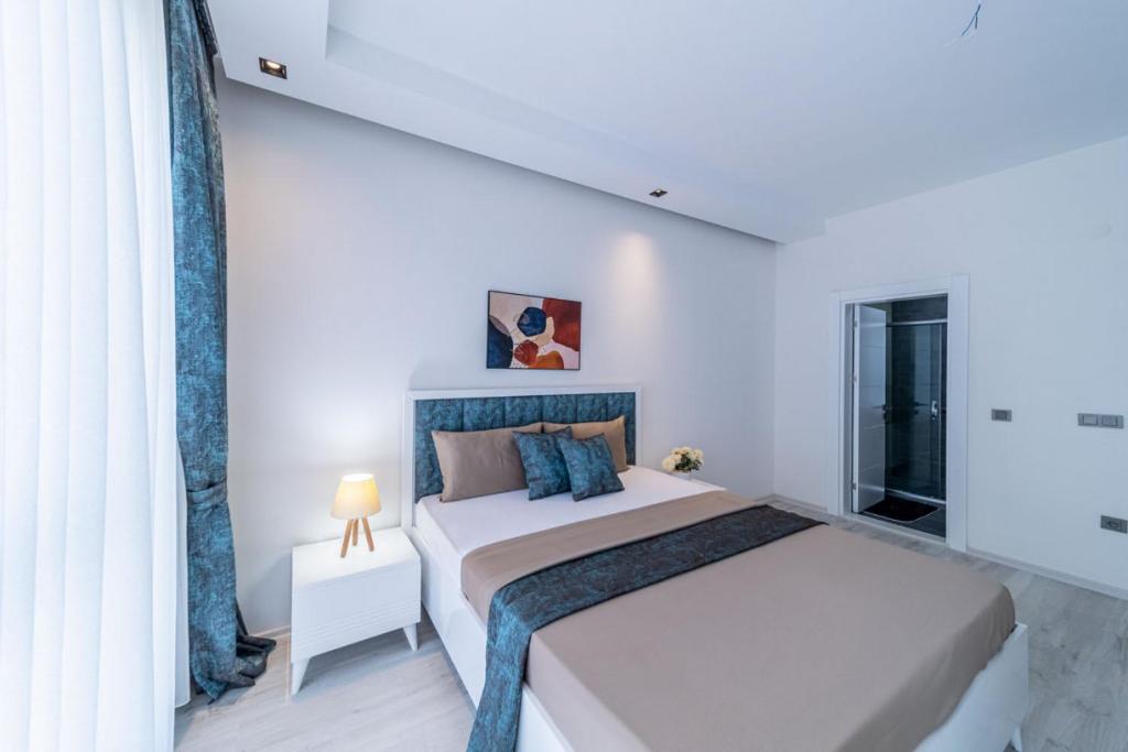 biała sypialnia z dużym łóżkiem i oknem w obiekcie Modern Apartment with Shared Sauna in Alanya w mieście Kargicak
