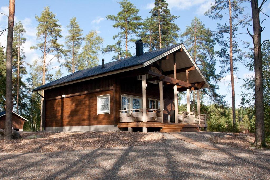 a cabin in the woods with a large deck at Villa Kilpikonna in Mikkeli
