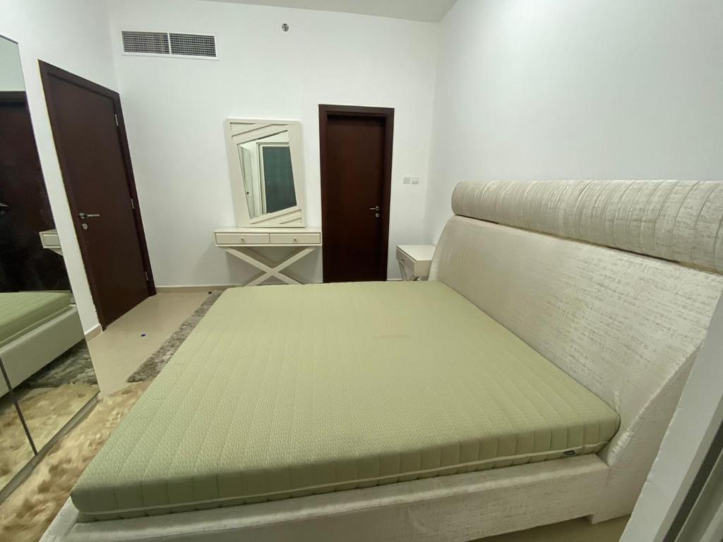Bett in einem Zimmer mit Spiegel in der Unterkunft OWN APARTMENT in Ajman 