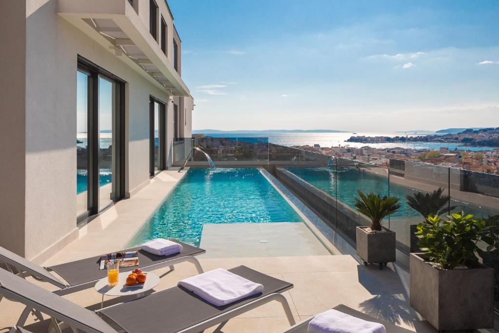 - une piscine avec vue sur l'océan depuis une maison dans l'établissement Villa Golden Hill with dream View prof Gym Wellness near Split, à Podstrana