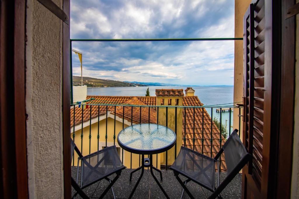 uma vista a partir de uma varanda com uma mesa e cadeiras em Studio Apartment Kos**** em Opatija