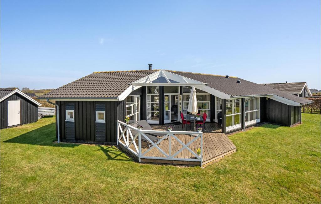 a black house with a deck in a yard at Cozy Home In Haderslev With Sauna in Haderslev