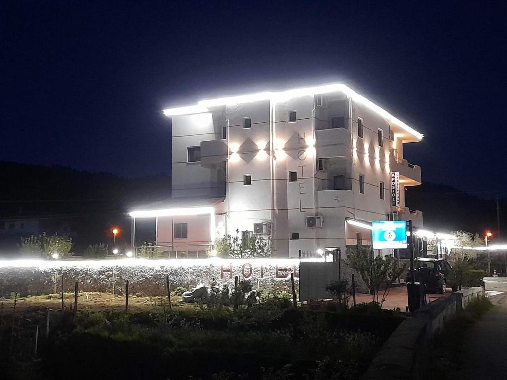 duży budynek z oświetleniem w nocy w obiekcie Hotel Apostoli w mieście Përmet