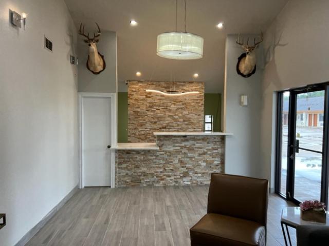 - un salon avec une cheminée et des bois sur le mur dans l'établissement GARDEN INN & Suites, à Hebbronville