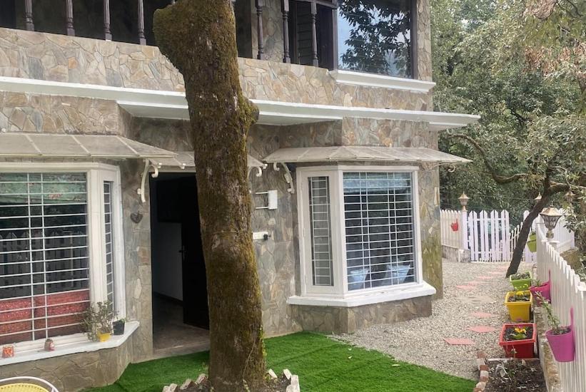a stone house with a tree in front of it at 2BHK Apartment In Mansion Near Nainital Lake in Nainital