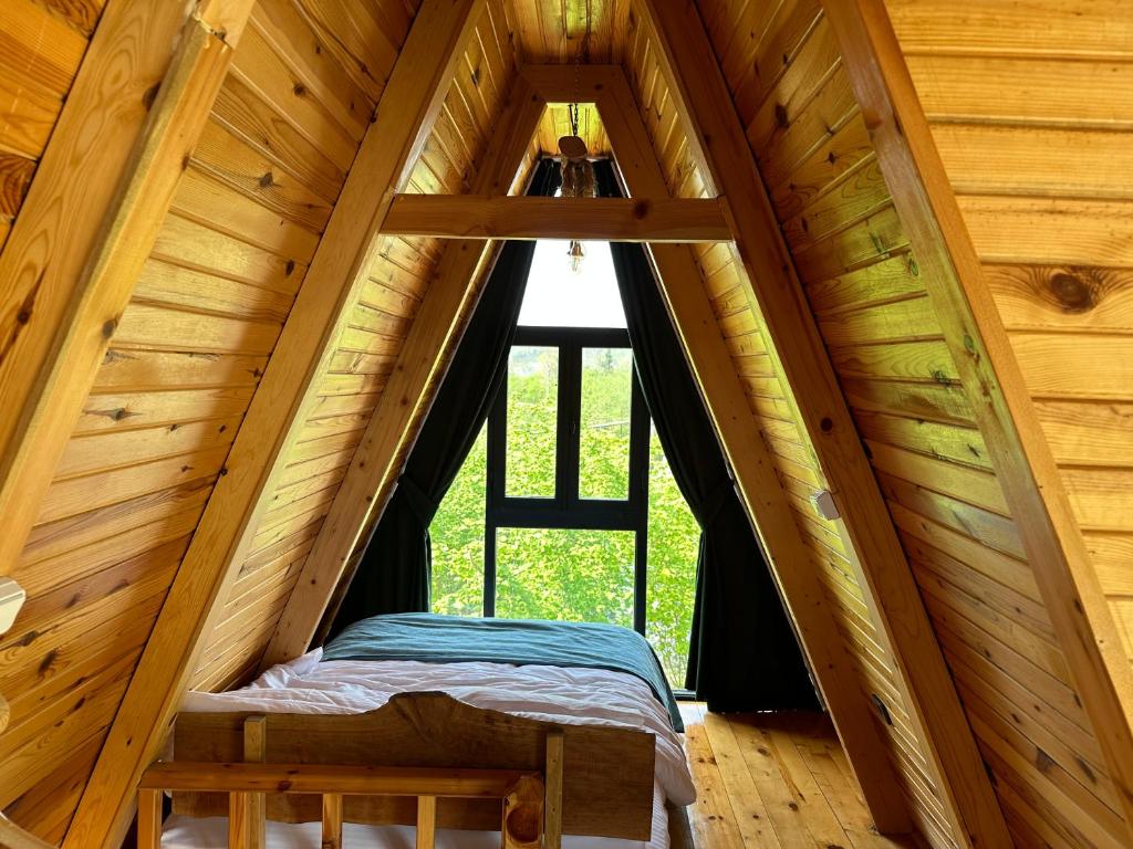 1 cama en el ático de una cabaña de madera en Yeşil Düş Tatil Köyü, en Fındıklı