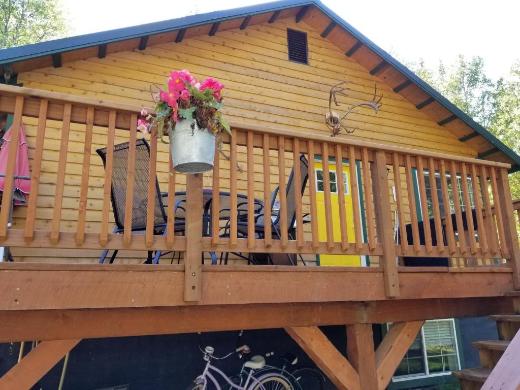 a screened in deck with chairs and a potted plant at Rustic Elegance in Talkeetna