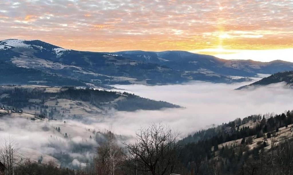 a view of a foggy valley with mountains and clouds at Cabana Bucuria Munților in Horea