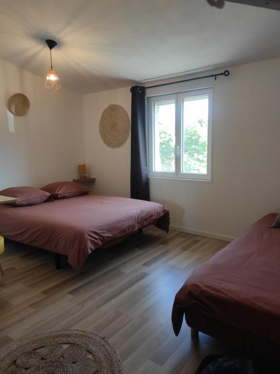 um quarto com 2 camas e uma janela em La Cigogne em Éclaron
