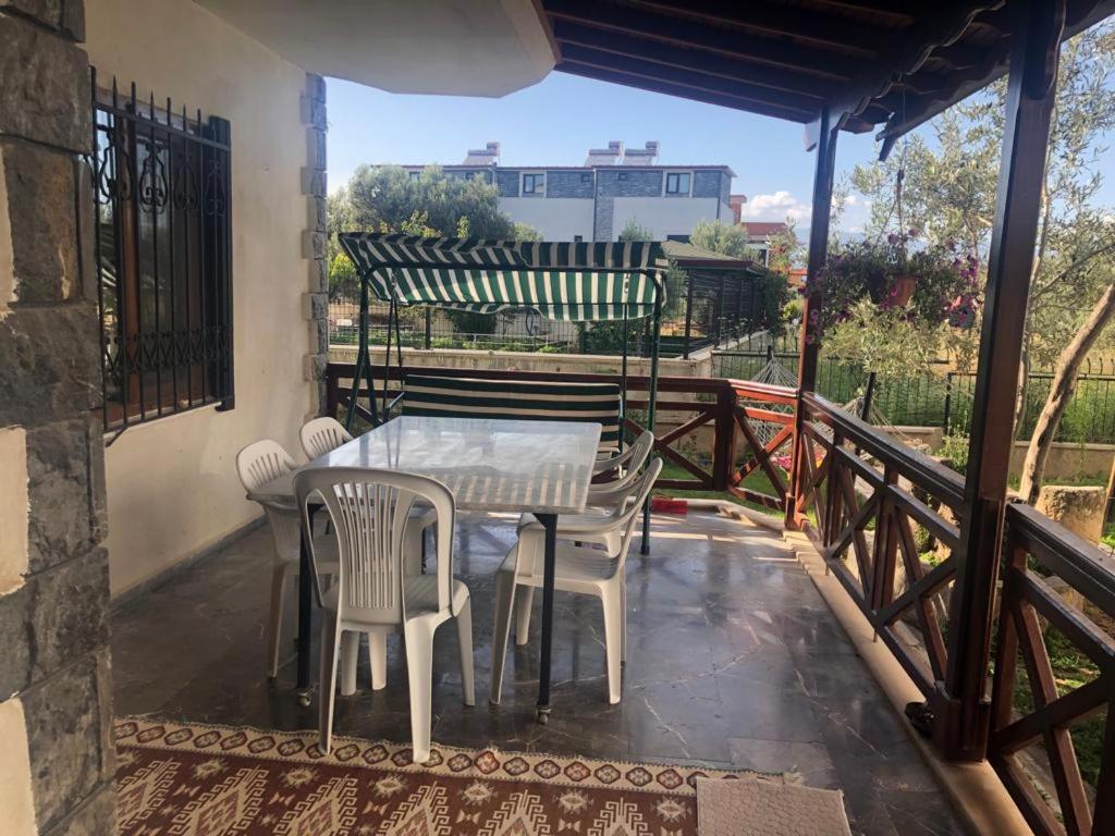 een patio met een tafel en stoelen op een balkon bij Yazlık in Burhaniye