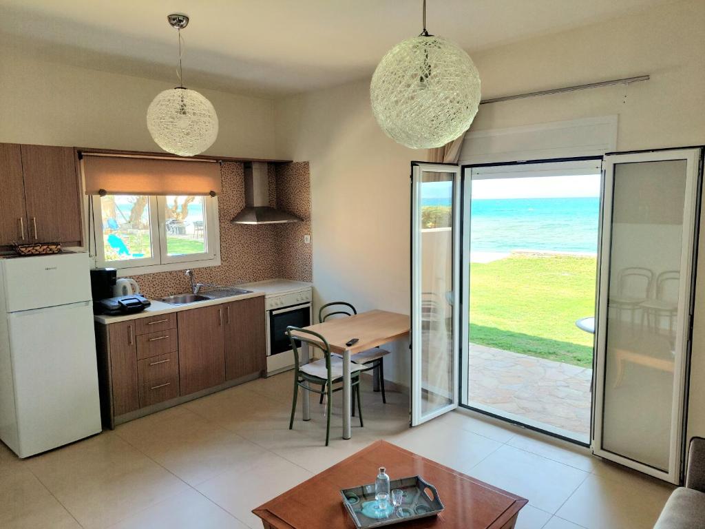 a kitchen with a table and a kitchen with a view of the ocean at Lila Villas in Stalos